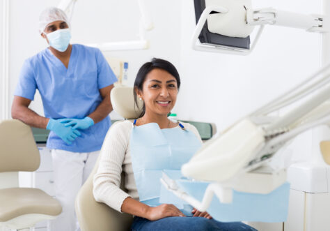 Portrait of satisfied woman visiting dentist giving thumbs up in the dental clinic.